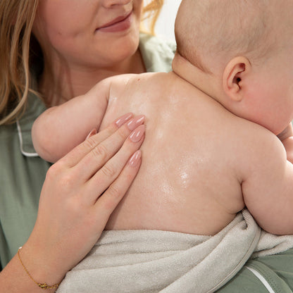 Woman holding a baby close, with a soft focus background