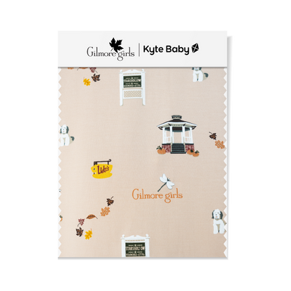GIlmore Girls Fabric swatch featuring Stars Hallow sign, gazebo, Lukes coffee sign, fall leaves, Gilmore Girls logo and a white and grey dog.