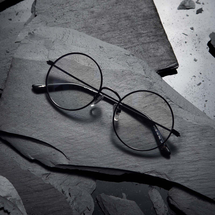 Flat-lay of Harry Potter x DIFF Harry Potter glasses lying folded on top of black broken stone