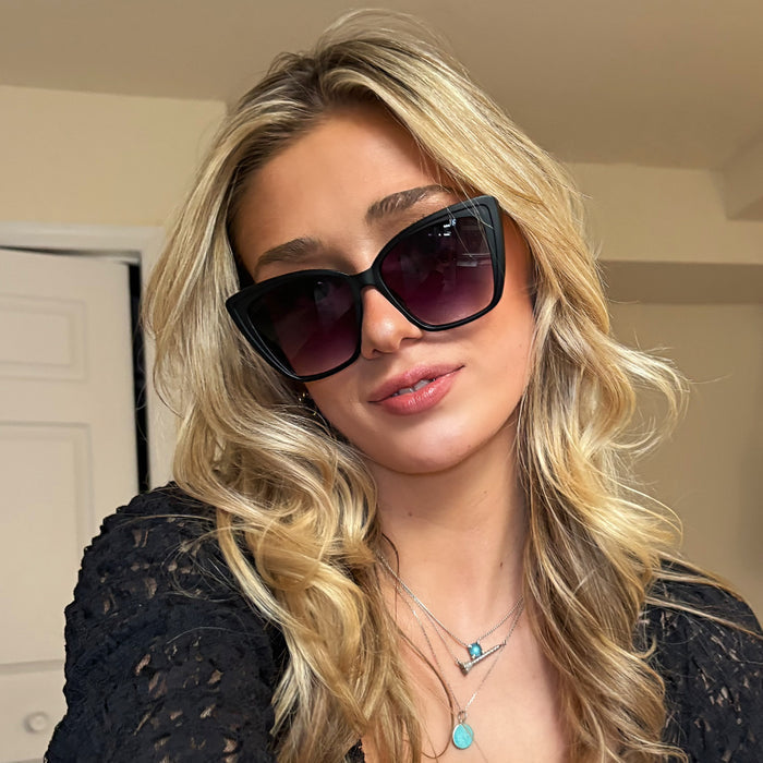 customer content - female wearing diff eyewear heidi cat eye sunglasses with a matte black frame and grey gradient sharp lenses front view