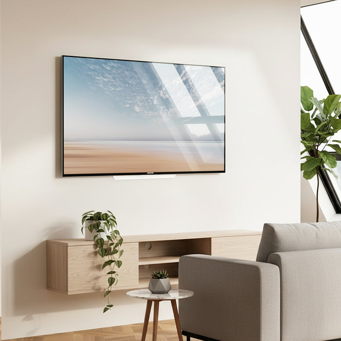 Modern living room with a TV mounted on the wall, a sofa, and decorative plants.