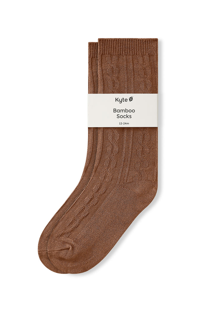 Knee high socks in latte laying flat on a white background.