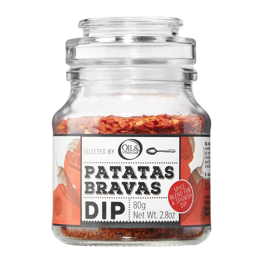 A glass jar containing Patatas Bravas dip mix with visible red and yellow herbs, labeled with the product name and weight (80g/2.8 oz).