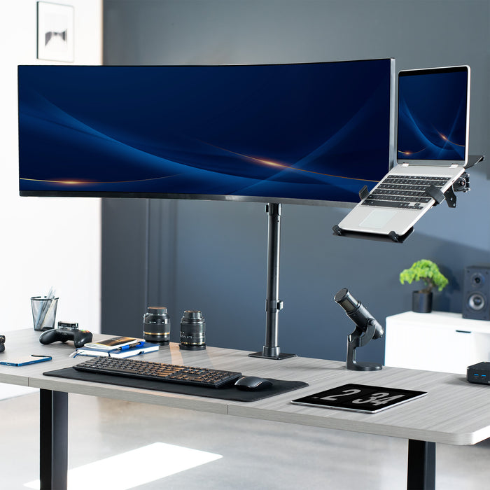 Desk setup with large monitor, laptop, keyboard, and mouse on a light gray desk.