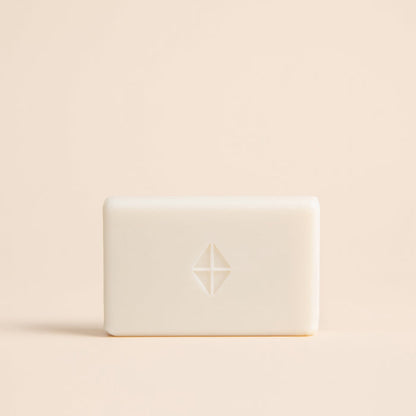 White bar of soap with a logo on a beige background